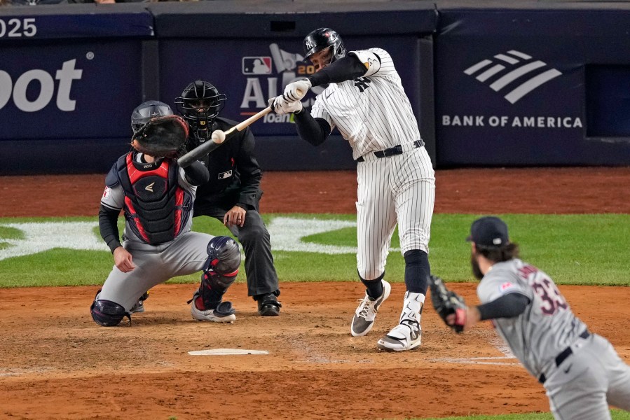 New York Yankees' Aaron Judge, center, hits a two-run home run off Cleveland Guardians relief pitcher Hunter Gaddis (33) during the seventh inning in Game 2 of the baseball AL Championship Series Tuesday, Oct. 15, 2024, in New York. (AP Photo/Seth Wenig)