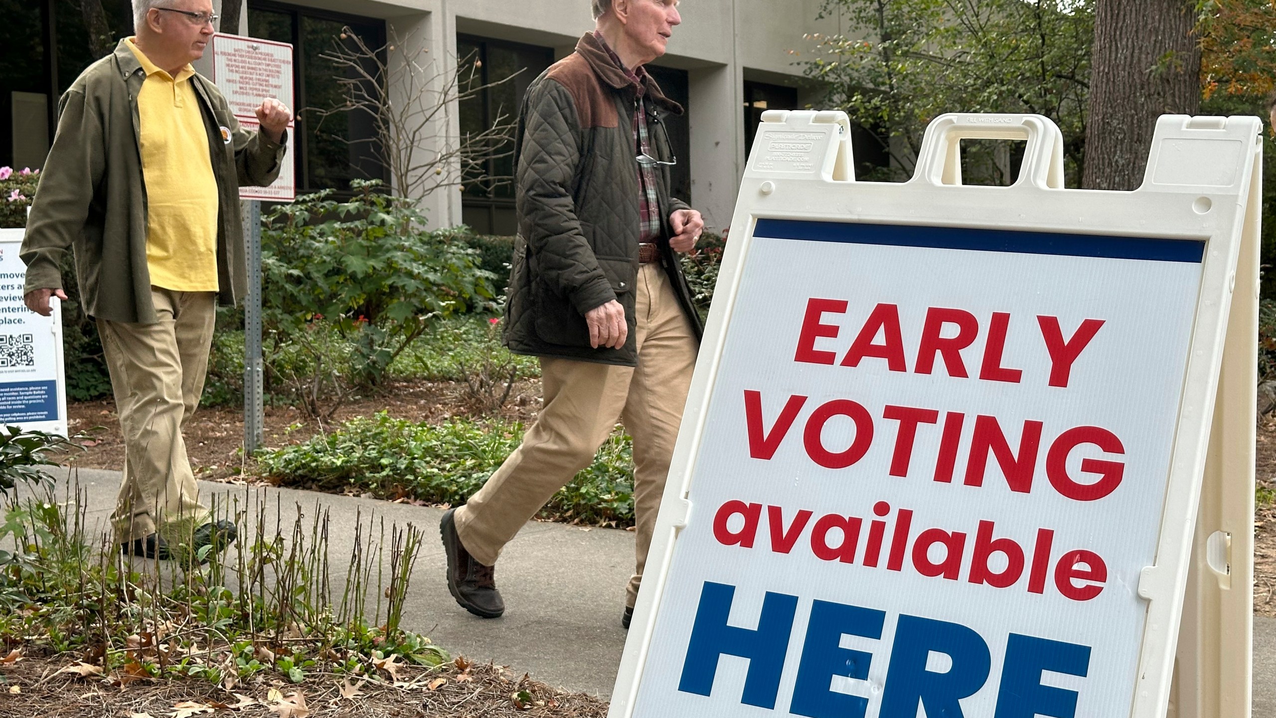 People leave after voting in the Atlanta suburb of Sandy Springs, Ga., on Tuesday, Oct. 15, 2024, the first day of early in-person voting in Georgia. (AP Photo/Jeff Amy)