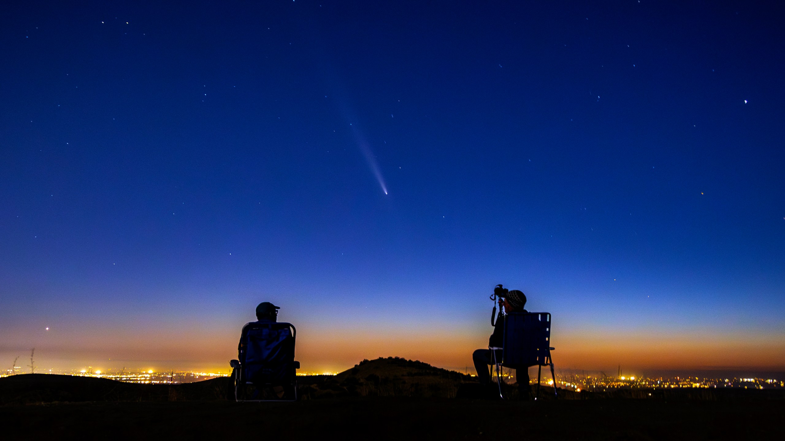 Comet Tsuchinshan-Atlas makes an appearance in the western night sky as amateur photographers Nolan Letellier, left, and Link Jackson observe on a ridge near the Dry Creek Trailhead in Boise, Idaho. Monday, Oct. 14, 2024 (AP Photo/Kyle Green)