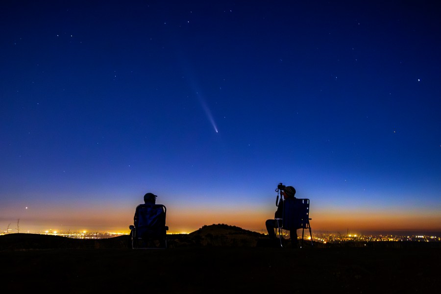 Comet Tsuchinshan-Atlas makes an appearance in the western night sky as amateur photographers Nolan Letellier, left, and Link Jackson observe on a ridge near the Dry Creek Trailhead in Boise, Idaho. Monday, Oct. 14, 2024 (AP Photo/Kyle Green)