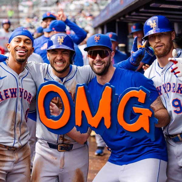 New York Mets' Francisco Lindor, left, Jose Iglesias, left center, David Peterson, right center, and Brandon Nimmo, right, celebrate in the dugout after taking the lead in the eighth inning of a baseball game against the Atlanta Braves, Monday, Sept. 30, 2024, in Atlanta. (AP Photo/Jason Allen)