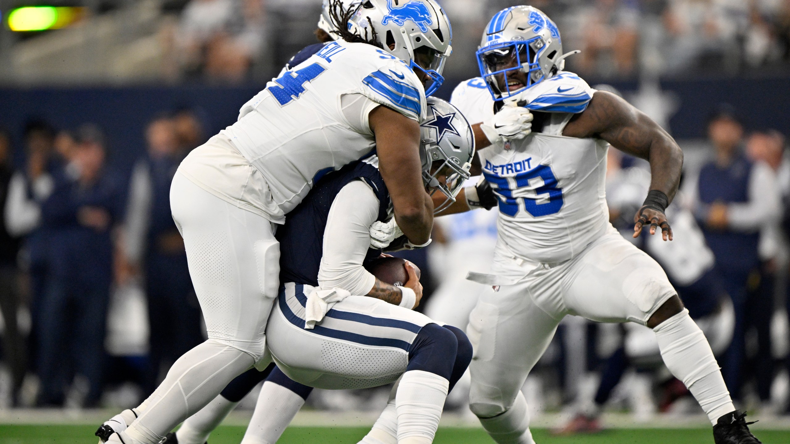 Detroit Lions defensive tackle Alim McNeill, left, sacks Dallas Cowboys quarterback Dak Prescott (4) as Josh Paschal (93) pressures in the first first half of an NFL football game in Arlington, Texas, Sunday, Oct. 13, 2024. (AP Photo/Jerome Miron)