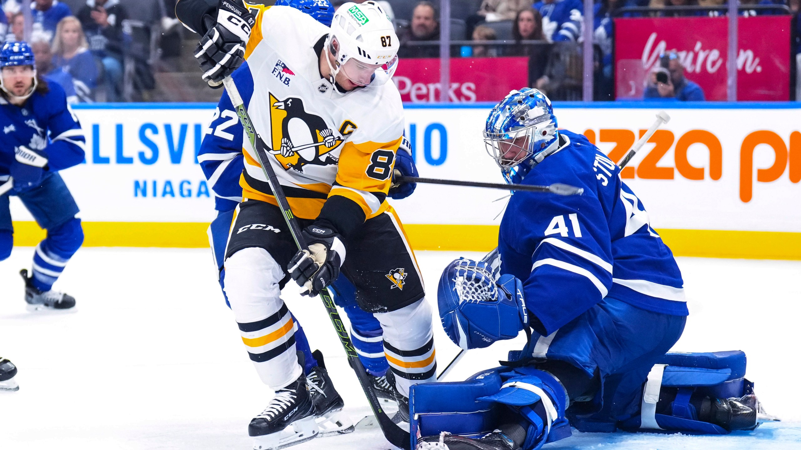 Toronto Maple Leafs goaltender Anthony Stolarz, right, saves a shot by Pittsburgh Penguins' Sidney Crosby (87) during third-period NHL hockey game action in Toronto, Saturday, Oct. 12, 2024. (Chris Young/The Canadian Press via AP)