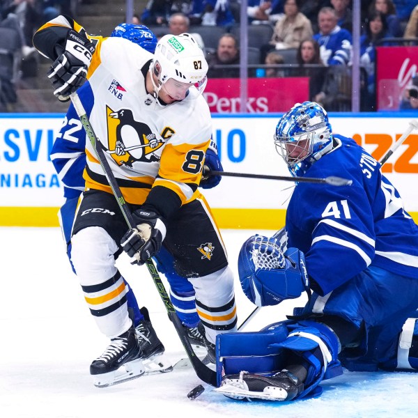 Toronto Maple Leafs goaltender Anthony Stolarz, right, saves a shot by Pittsburgh Penguins' Sidney Crosby (87) during third-period NHL hockey game action in Toronto, Saturday, Oct. 12, 2024. (Chris Young/The Canadian Press via AP)