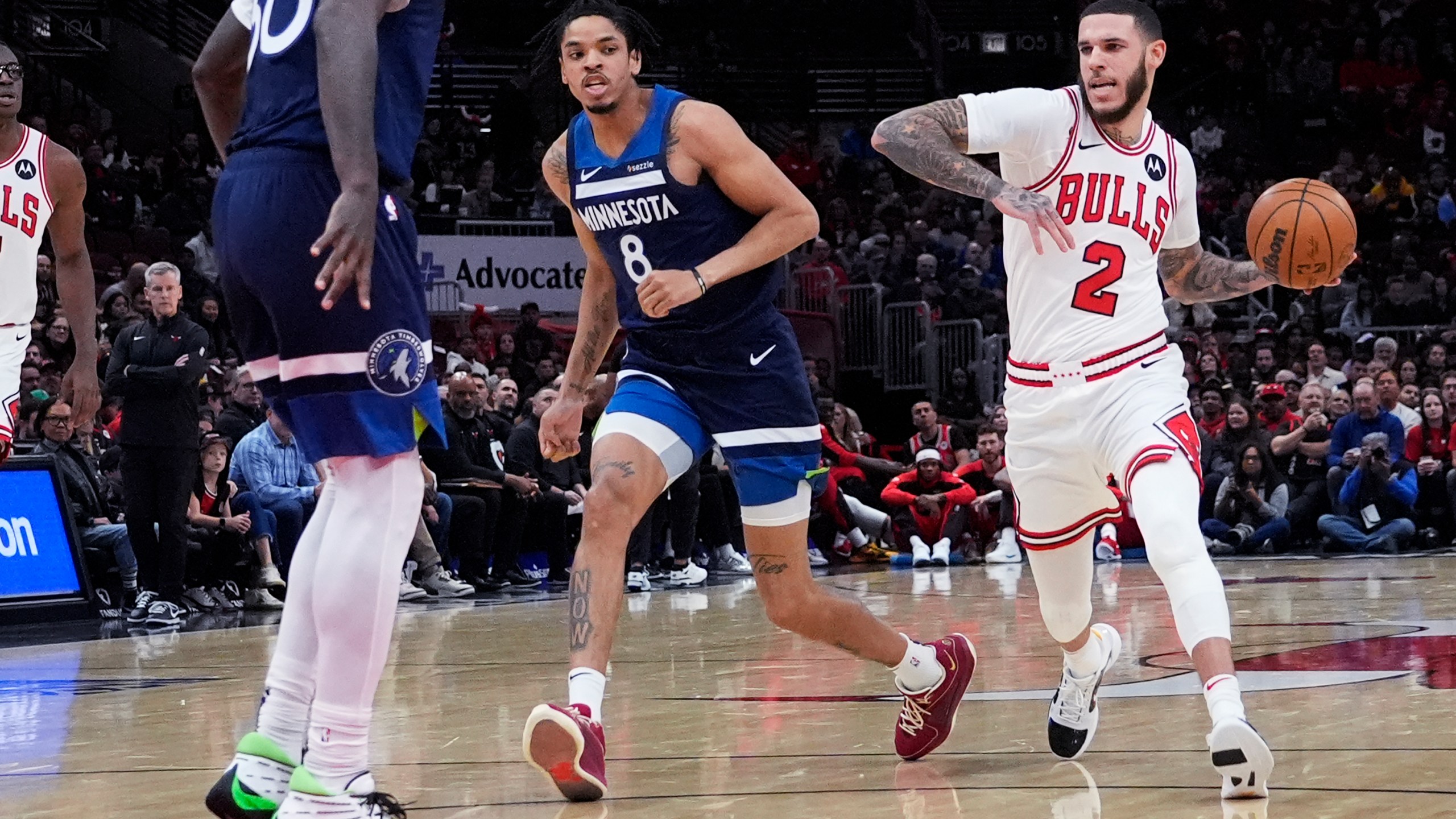 Chicago Bulls guard Lonzo Ball (2) drives as he looks to pass against Minnesota Timberwolves forward Josh Minott (8) and forward Julius Randle during the first half of an NBA preseason basketball game in Chicago, Wednesday, Oct. 16, 2024. (AP Photo/Nam Y. Huh)