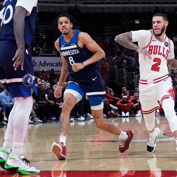 Chicago Bulls guard Lonzo Ball (2) drives as he looks to pass against Minnesota Timberwolves forward Josh Minott (8) and forward Julius Randle during the first half of an NBA preseason basketball game in Chicago, Wednesday, Oct. 16, 2024. (AP Photo/Nam Y. Huh)