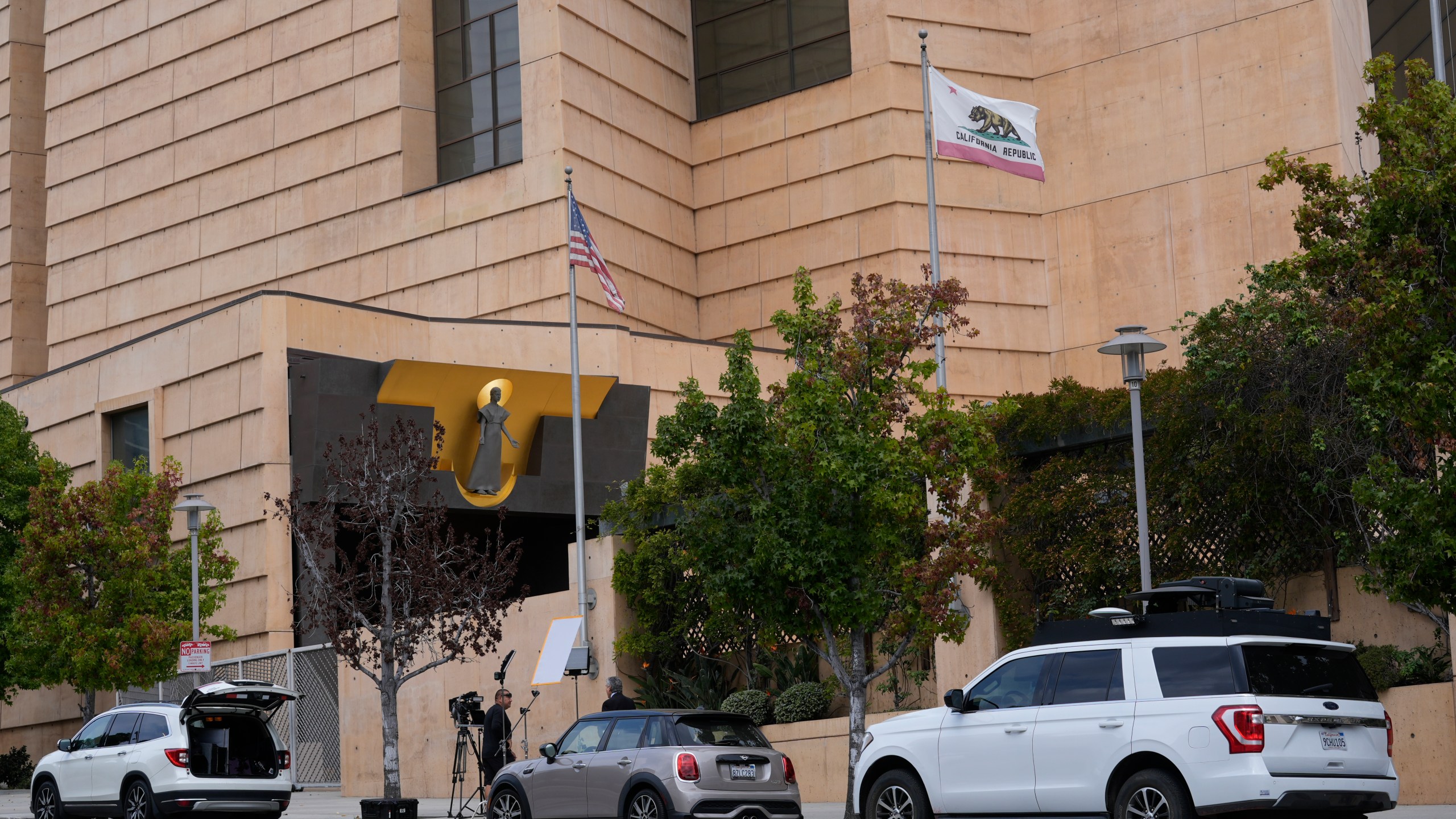 Television news crews report the largest single child sex abuse settlement with a Catholic archdiocese outside the Cathedral of Our Lady of Angels in Los Angeles, Thursday, Oct. 17, 2024. The Archdiocese of Los Angeles has agreed to pay $880 million to victims of clergy sexual abuse dating back decades. (AP Photo/Damian Dovarganes)