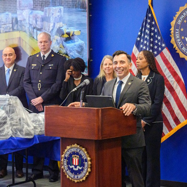 United States Attorney Martin Estrada, at podium, smiles as he's joined by federal, local, and international officials, to announce federal charges and arrests of alleged members of a transnational drug trafficking operation that routinely shipped hundreds of kilograms of cocaine from Colombia, through Mexico and Southern California, to Canada and other locations in the United States, during a news conference at the FBI offices in Los Angeles, Thursday, Oct. 17, 2024. (AP Photo/Damian Dovarganes)