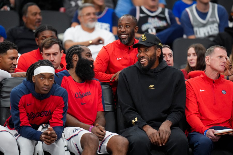 Los Angeles Clippers' James Harden, center left, shares a light moment with Kawhi Leonard during the second half of an NBA preseason basketball game against the Dallas Mavericks Monday, Oct. 14, 2024, in Inglewood, Calif. (AP Photo/Jae C. Hong)