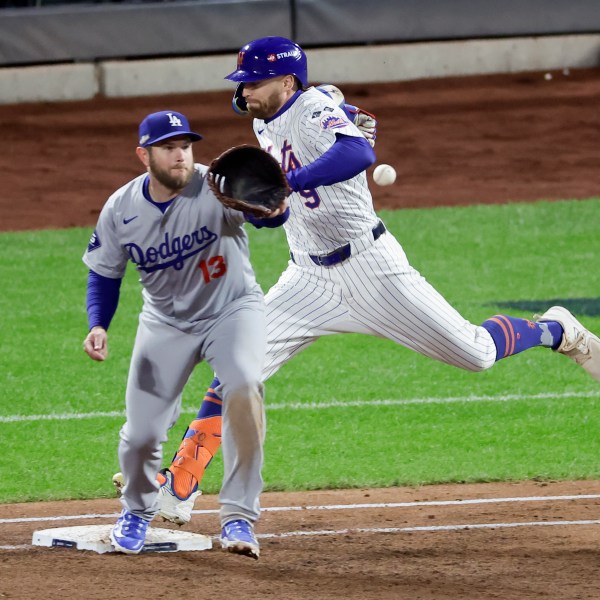 New York Mets' Brandon Nimmo is safe at first past Los Angeles Dodgers first baseman Max Muncy during the third inning in Game 4 of a baseball NL Championship Series, Thursday, Oct. 17, 2024, in New York. (AP Photo/Adam Hunger)