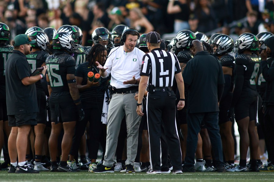 Oregon head coach Dan Lanning, center left, talks with a referee, center right, during an NCAA college football game against Ohio State, Saturday, Oct. 12, 2024, in Eugene, Ore. (AP Photo/Lydia Ely)