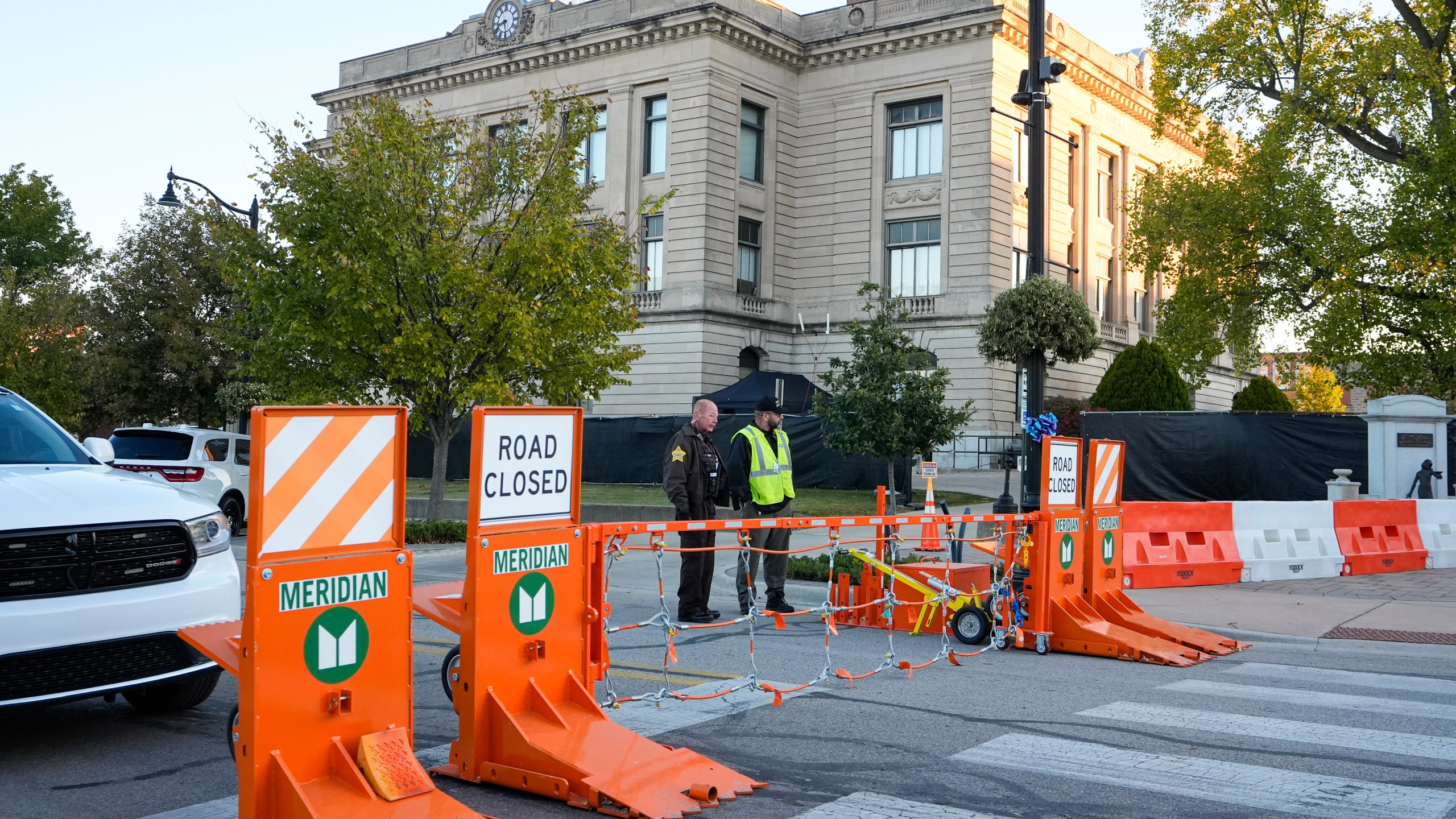 Security stand by a gate outside the Carroll County Courthouse where the trial of Richard Allen, accused of the slayings of two teenage girls in 2017, is set to begin in Delphi, Ind., Friday, Oct. 18, 2024. (AP Photo/Michael Conroy)