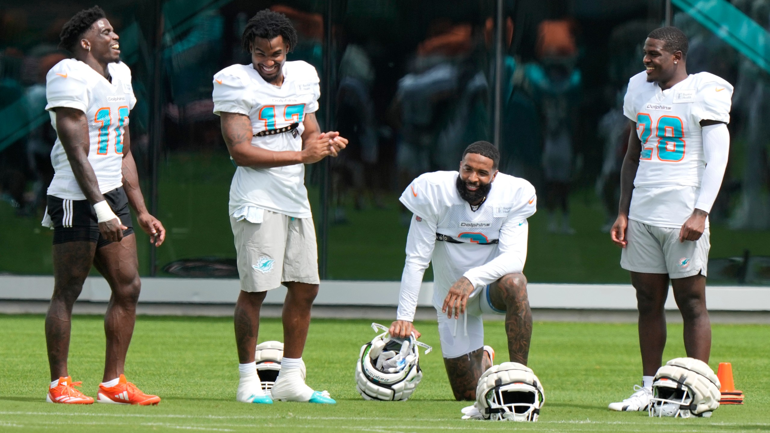 Miami Dolphins wide receiver Odell Beckham Jr., second from right, talks with wide receiver Tyreek Hill (10), wide receiver Jaylen Waddle (17) and running back De'Von Achane (28) during practice at the NFL football team's training facility, Thursday, Oct. 3, 2024, in Miami Gardens, Fla. (AP Photo/Lynne Sladky)