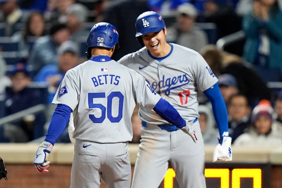 Los Angeles Dodgers' Shohei Ohtani celebrates after scoring on Mookie Betts two-run home run against the New York Mets during the sixth inning in Game 4 of a baseball NL Championship Series, Thursday, Oct. 17, 2024, in New York. (AP Photo/Frank Franklin II)