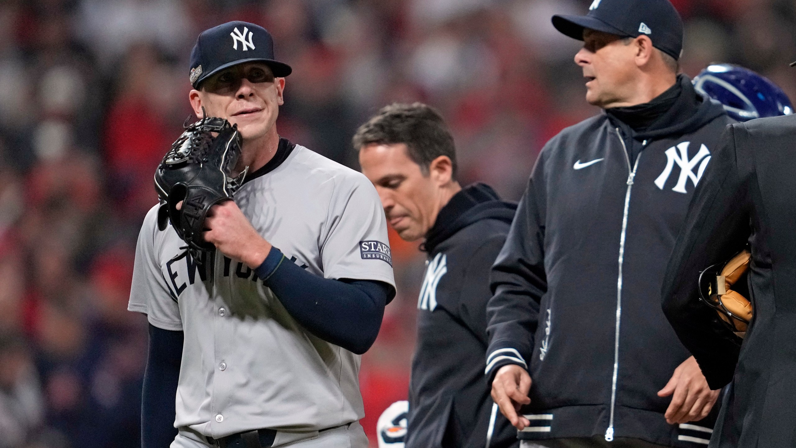 New York Yankees relief pitcher Ian Hamilton, left, leaves the game during the sixth inning in Game 3 of the baseball AL Championship Series against the Cleveland GuardiansvThursday, Oct. 17, 2024, in Cleveland.(AP Photo/Godofredo Vásquez )