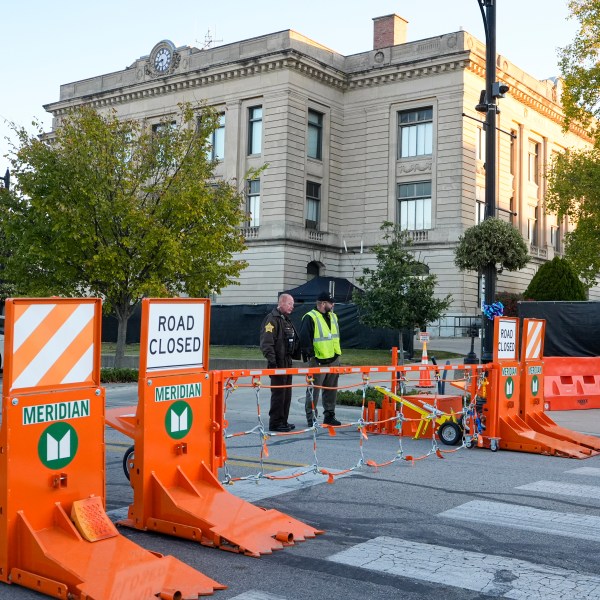 Security stand by a gate outside the Carroll County Courthouse where the trial of Richard Allen, accused of the slayings of two teenage girls in 2017, is set to begin in Delphi, Ind., Friday, Oct. 18, 2024. (AP Photo/Michael Conroy)