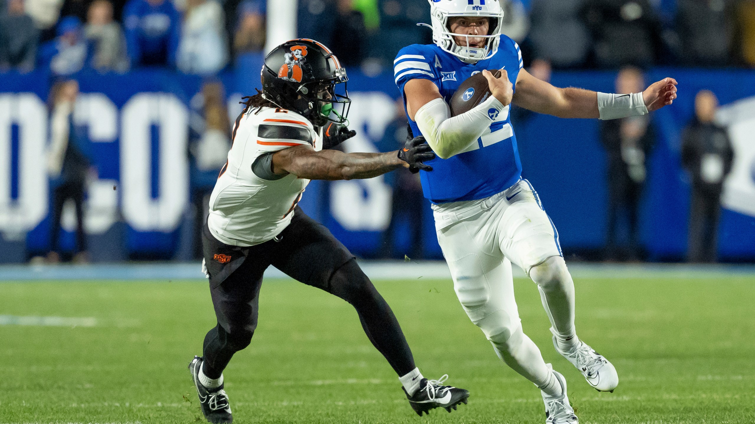 BYU quarterback Jake Retzlaff runs the ball ahead of Oklahoma State cornerback Korie Black in the second half of an NCAA college football game, Friday, Oct. 18, 2024, in Provo, Utah. (AP Photo/Spenser Heaps)