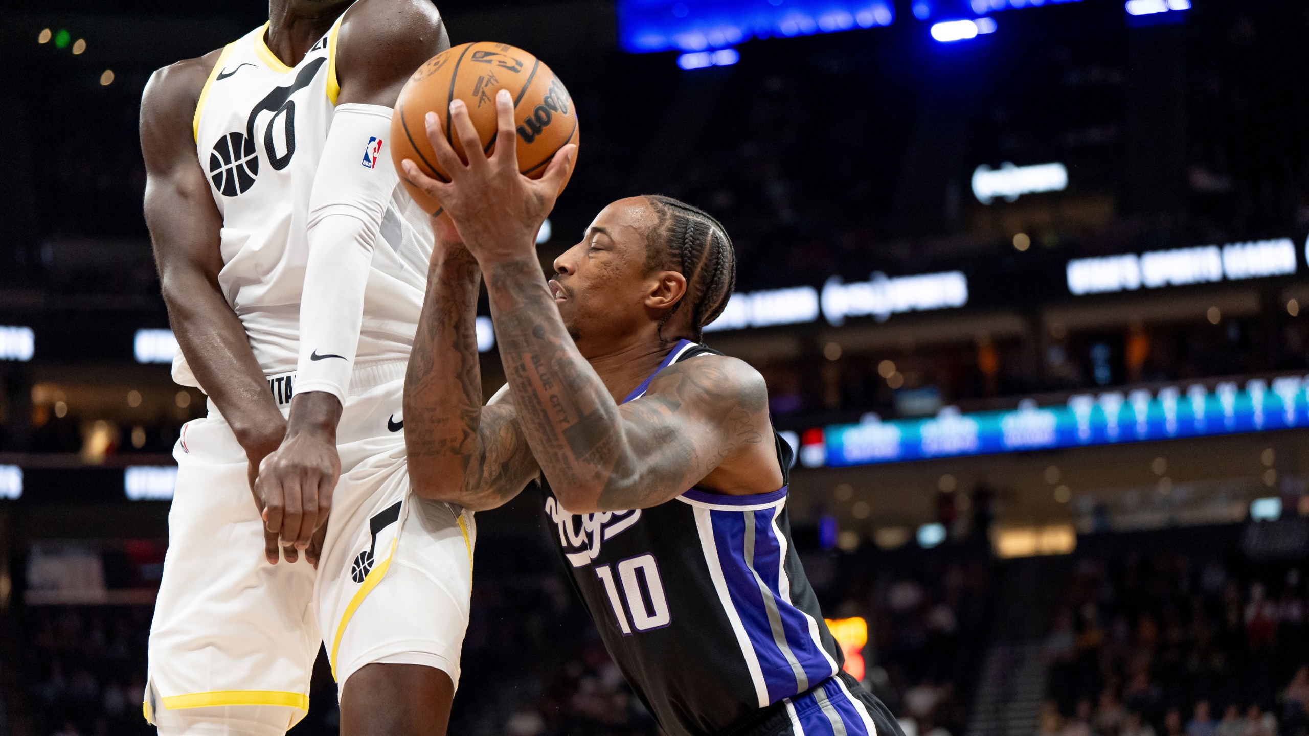 Utah Jazz forward Taylor Hendricks (0) draws the foul charge as Sacramento Kings forward DeMar DeRozan (10) shoots in the first half of an NBA preseason basketball game, Tuesday, Oct. 15, 2024, in Salt Lake City. (AP Photo/Spenser Heaps)