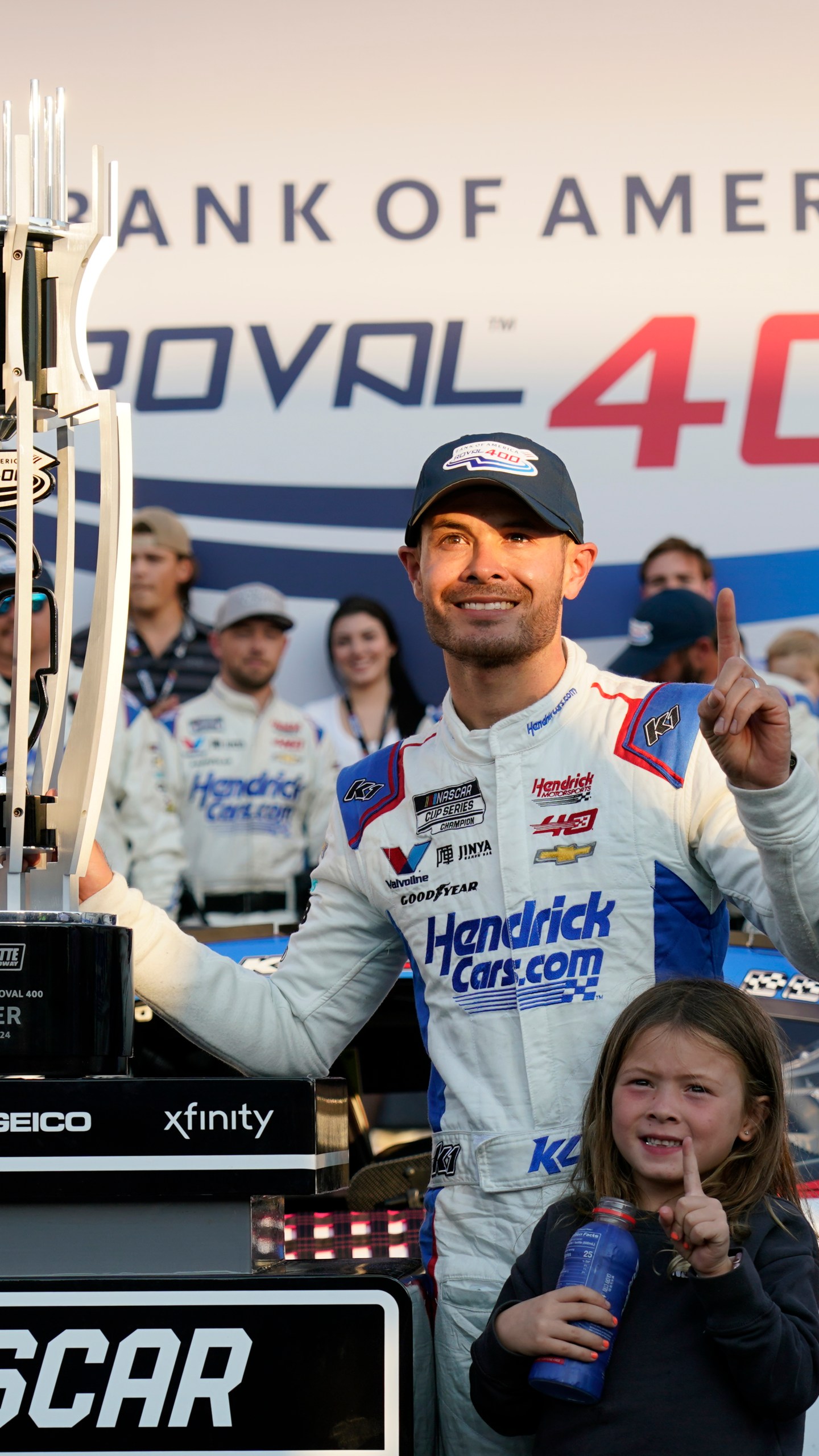 Kyle Larson poses with the trophy with his daughter Audrey, 6, after winning a NASCAR Cup Series auto race at Charlotte Motor Speedway in Concord, N.C., Sunday, Oct. 13, 2024. (AP Photo/Chuck Burton)