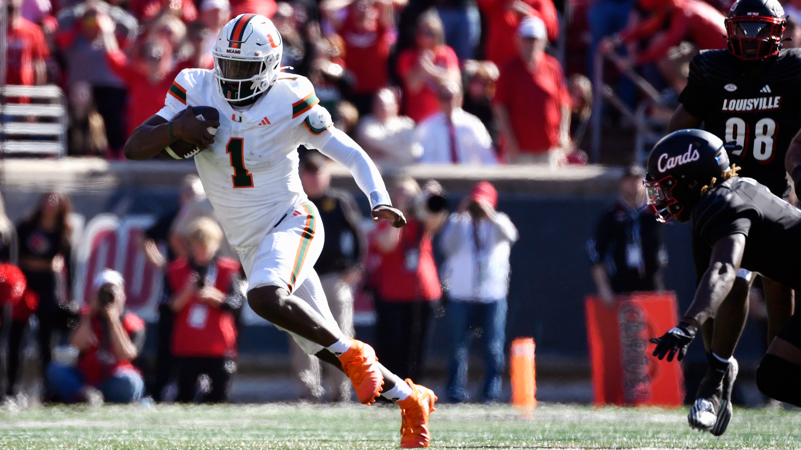 Miami quarterback Cam Ward (1) runs from the pursuit of the Louisville defense during the second half of an NCAA college football game in Louisville, Ky., Saturday, Oct. 19, 2024. Miami won 52-45. (AP Photo/Timothy D. Easley)