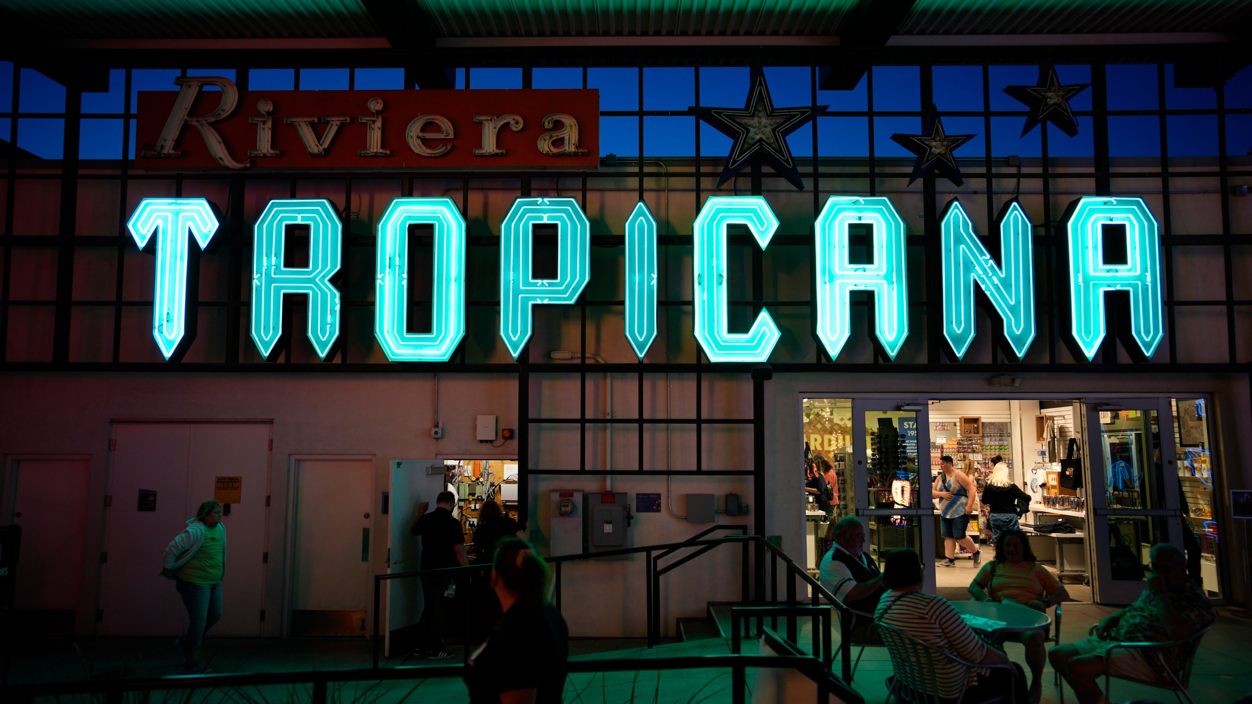 People walk by a sign for the Tropicana on display at the Neon Museum, Wednesday, April 3, 2024, in Las Vegas. (AP Photo/John Locher)