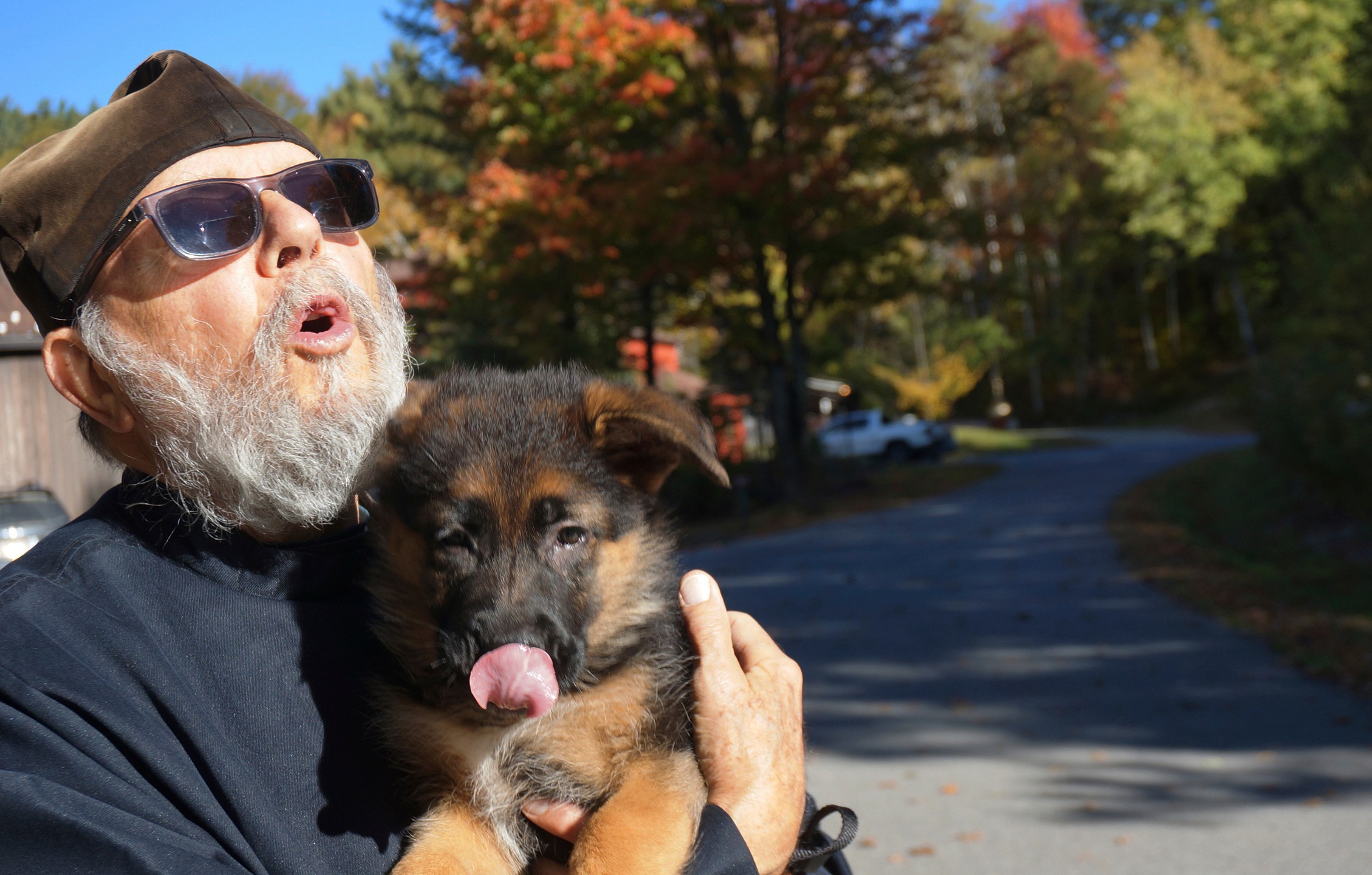 Brother Luke, an Orthodox Christian monk, holds his 10-week-old German shepherd Pyrena on the grounds of the New Skete monastery, where he directs the dog breeding program that has provided both financial and spiritual support to the community for decades outside Cambridge, N.Y., on Oct. 12, 2024. (AP Photo/Giovanna Dell’Orto)