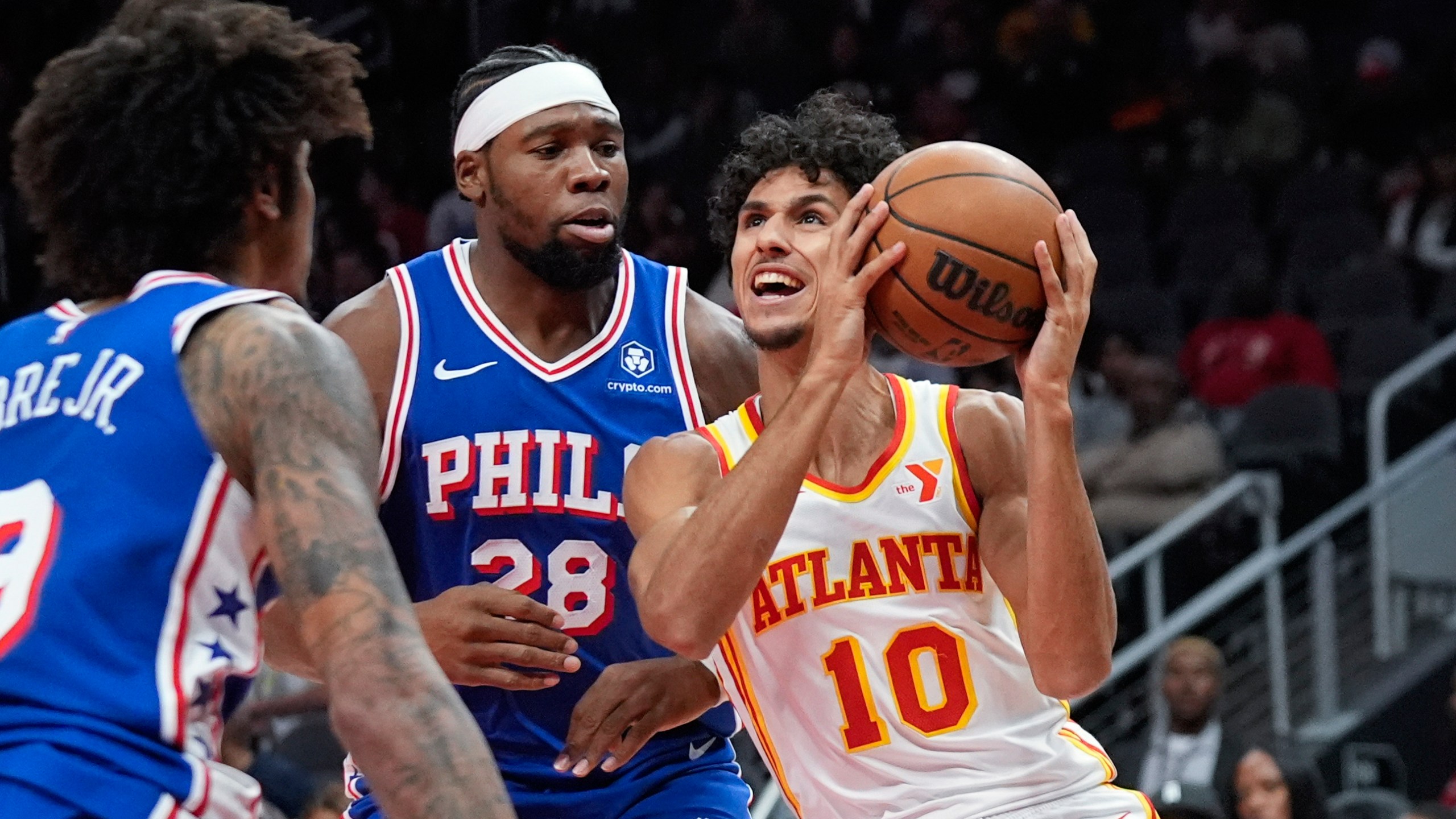 Atlanta Hawks forward Zaccharie Risacher (10) tries to get past Philadelphia 76ers forward Guerschon Yabusele (28) in the first half of a preseason NBA basketball game Monday, Oct. 14, 2024, in Atlanta. (AP Photo/John Bazemore)