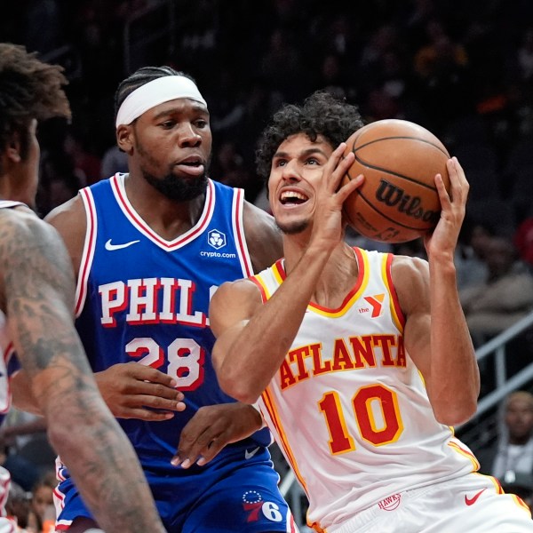 Atlanta Hawks forward Zaccharie Risacher (10) tries to get past Philadelphia 76ers forward Guerschon Yabusele (28) in the first half of a preseason NBA basketball game Monday, Oct. 14, 2024, in Atlanta. (AP Photo/John Bazemore)