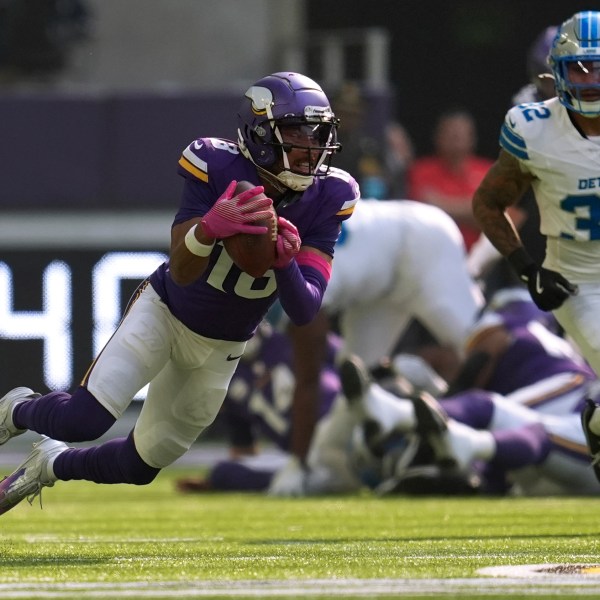 Minnesota Vikings wide receiver Justin Jefferson (18) catches a pass as Detroit Lions safety Brian Branch (32) defends during the first half of an NFL football game Sunday, Oct. 20, 2024, in Minneapolis. (AP Photo/Abbie Parr)