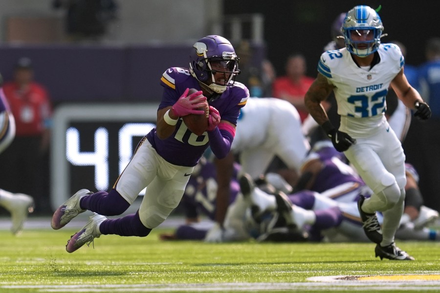 Minnesota Vikings wide receiver Justin Jefferson (18) catches a pass as Detroit Lions safety Brian Branch (32) defends during the first half of an NFL football game Sunday, Oct. 20, 2024, in Minneapolis. (AP Photo/Abbie Parr)