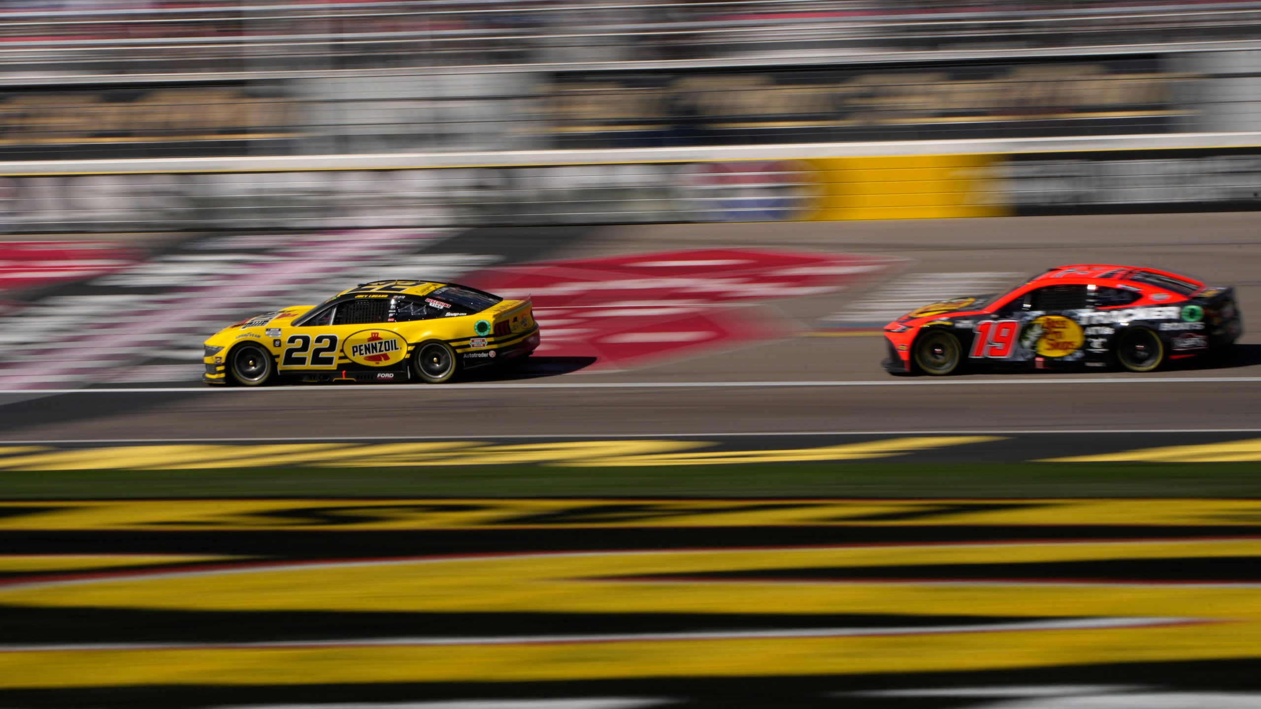 NASCAR Cup Series drivers Joey Logano (22) and Martin Truex Jr. (19) race during a NASCAR Cup Series auto race Sunday, Oct. 20, 2024, in Las Vegas. (AP Photo/John Locher)