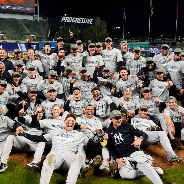 New York Yankees players pose for a team picture after Game 5 of the baseball AL Championship Series against the Cleveland Guardians Saturday, Oct. 19, 2024, in Cleveland. The Yankees won 5-2 to advance to the World Series. (AP Photo/Sue Ogrocki)