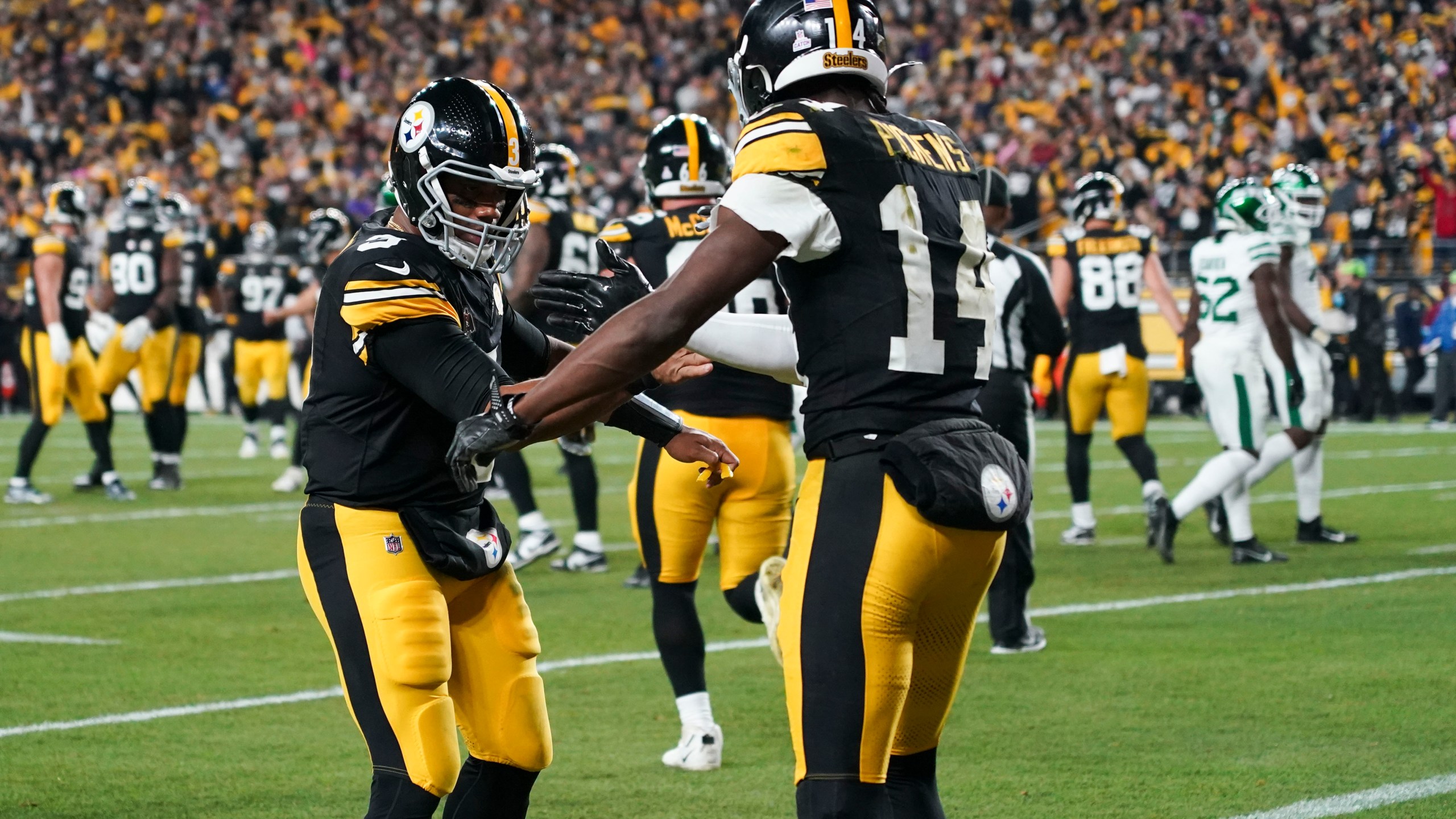 Pittsburgh Steelers wide receiver George Pickens (14) celebrates his touchdown reception against New York Jets with Pittsburgh Steelers quarterback Russell Wilson (3) the first half of an NFL football game in Pittsburgh, Sunday, Oct. 20, 2024. (AP Photo/Matt Freed)