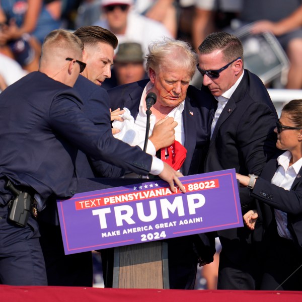 FILE - Republican presidential candidate former President Donald Trump is helped off the stage at a campaign event in Butler, Pa., July 13, 2024. (AP Photo/Gene J. Puskar, File)