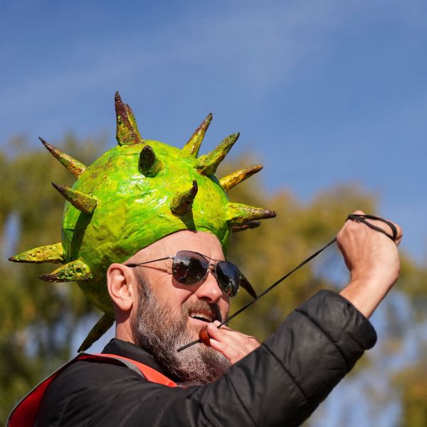 Competitor Neil Morbey wearing a conker themed hat takes part in the annual World Conker Championships at the Shuckburgh Arms in Southwick, Peterborough, England, Sunday Oct. 13, 2024. (Jacob King/PA via AP)