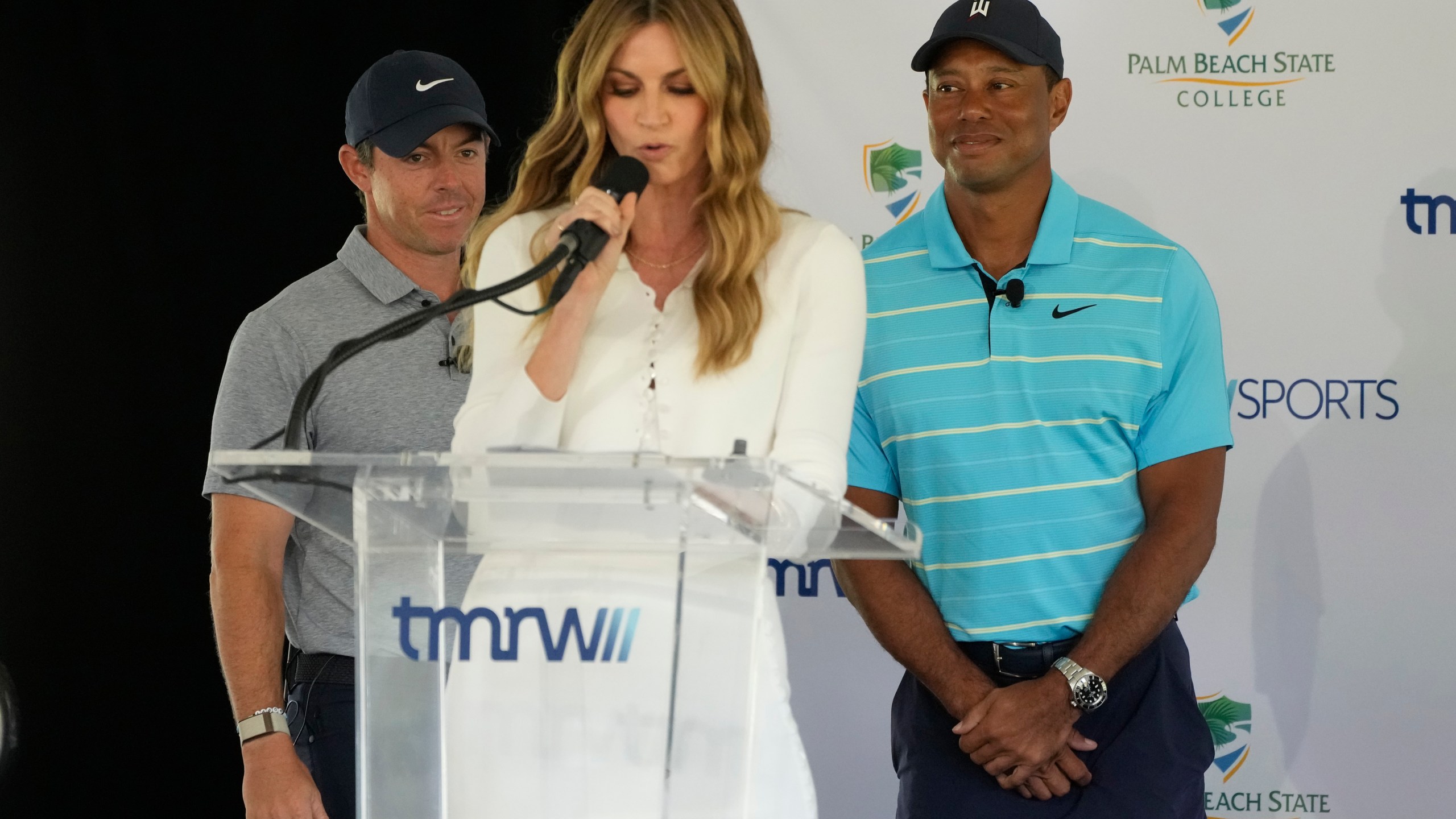 Host Erin Andrews, center, introduces golfers Tiger Woods, right, and Rory McIlroy during a news conference announcing the future home of TGL, a new tech-infused, team golf league, Tuesday, Feb. 21, 2023, on the campus of Palm Beach State College in Palm Beach Gardens, Fla. (AP Photo/Wilfredo Lee)