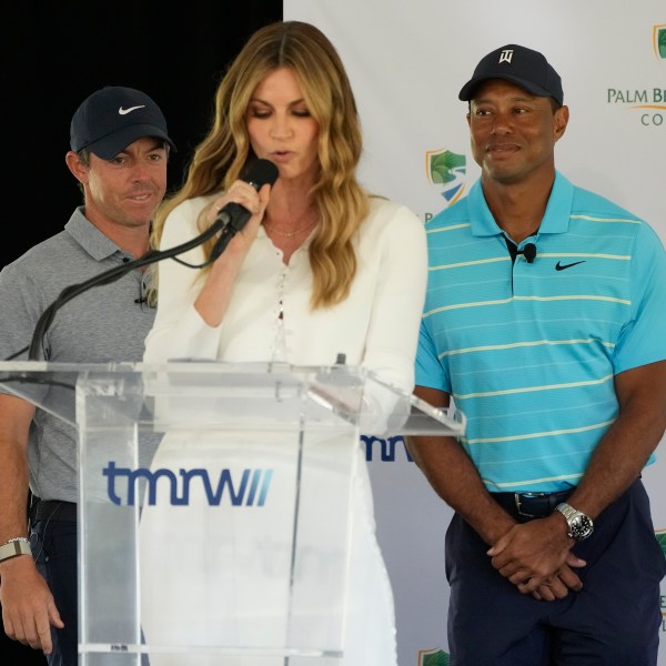 Host Erin Andrews, center, introduces golfers Tiger Woods, right, and Rory McIlroy during a news conference announcing the future home of TGL, a new tech-infused, team golf league, Tuesday, Feb. 21, 2023, on the campus of Palm Beach State College in Palm Beach Gardens, Fla. (AP Photo/Wilfredo Lee)