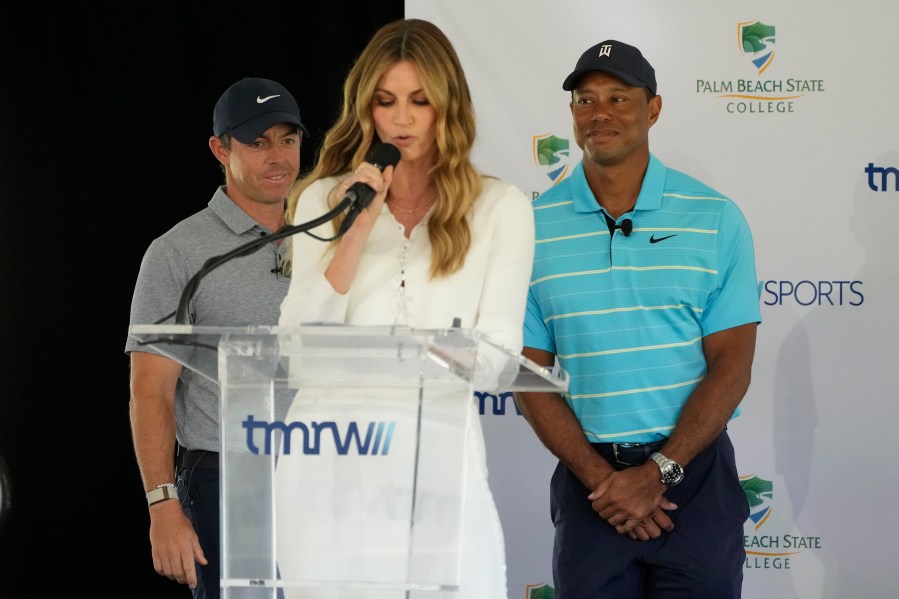 Host Erin Andrews, center, introduces golfers Tiger Woods, right, and Rory McIlroy during a news conference announcing the future home of TGL, a new tech-infused, team golf league, Tuesday, Feb. 21, 2023, on the campus of Palm Beach State College in Palm Beach Gardens, Fla. (AP Photo/Wilfredo Lee)