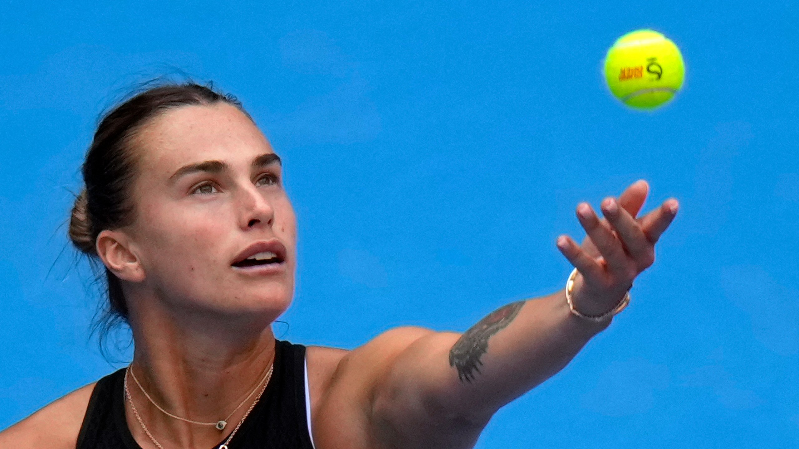 Aryna Sabalenka of Belarus tosses the ball to serve against Karolina Muchova of the Czech Republic during their women's singles quarterfinals match of the China Open tennis tournament, at the National Tennis Center in Beijing, Friday, Oct. 4, 2024. (AP Photo/Andy Wong)