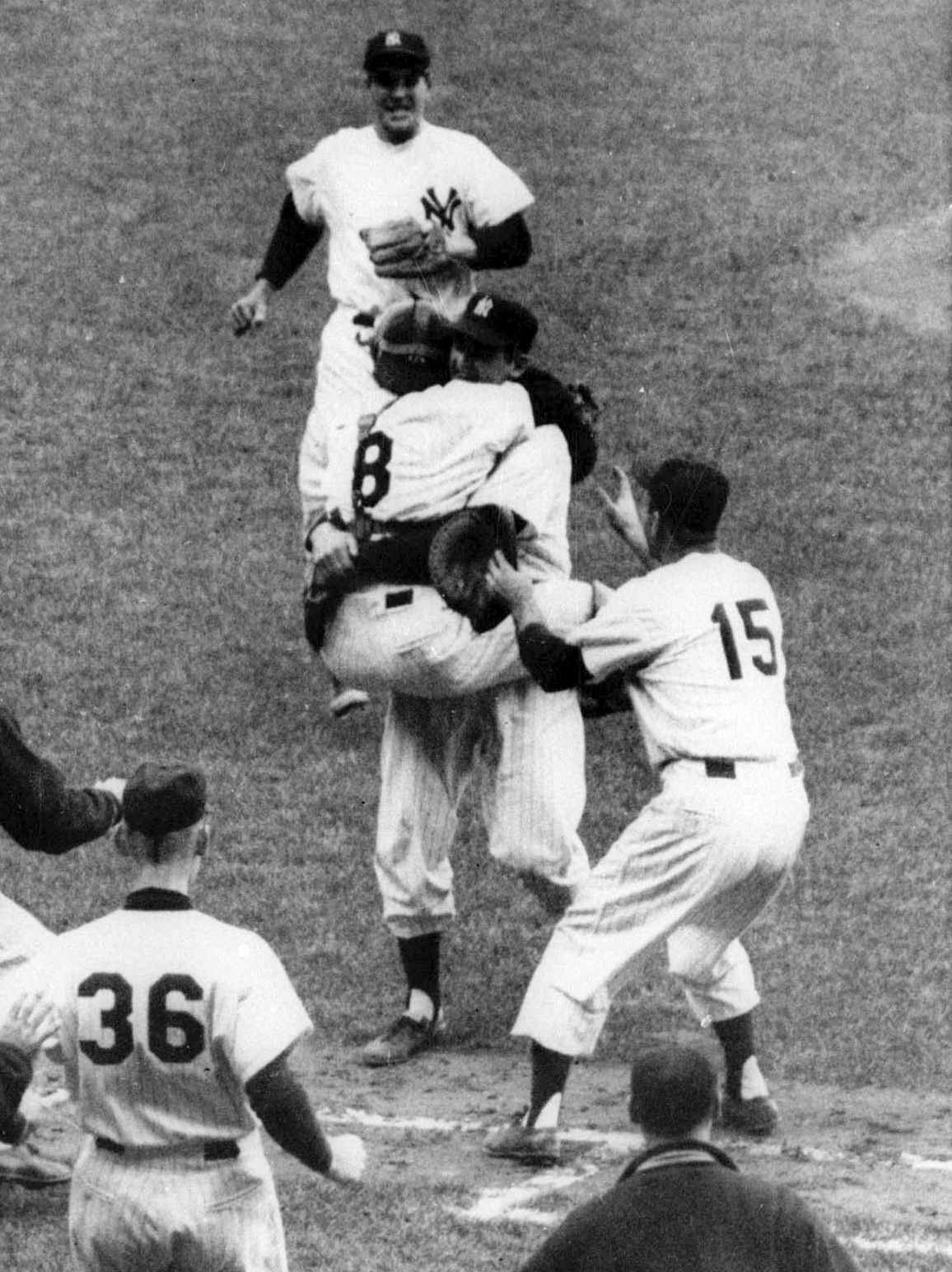 FILE - New York Yankees catcher Yogi Berra (8) jumps into the arms of pitcher Don Larsen after Larsen pitched the first perfect game in World Series history, defeating the Dodgers 2-0 at New York's Yankee Stadium, Oct. 8, 1956. (AP Photo, File)