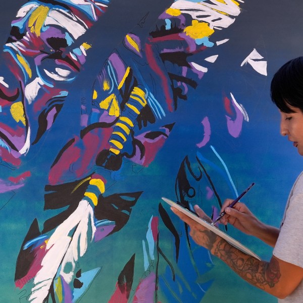 Artist Richelle Key works on the painting "Democracy Is Indigenous" during an Indigenous Peoples' Day event Monday, Oct. 14, 2024, in Phoenix. (AP Photo/Ross D. Franklin)