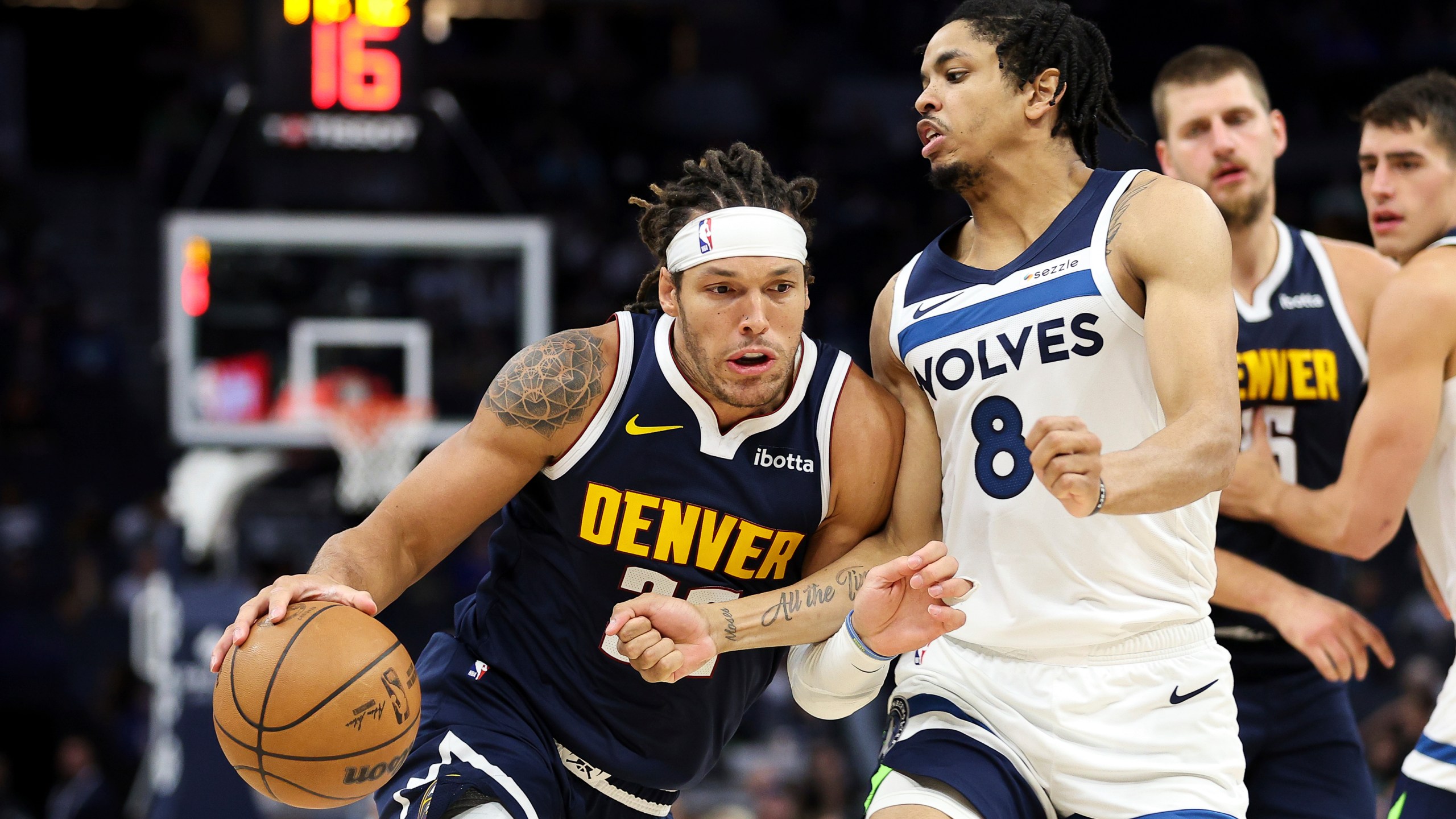 Denver Nuggets forward Aaron Gordon, left, drives past Minnesota Timberwolves forward Josh Minott (8) during the second half of a preseason NBA basketball game, Thursday, Oct. 17, 2024, in Minneapolis. (AP Photo/Matt Krohn)