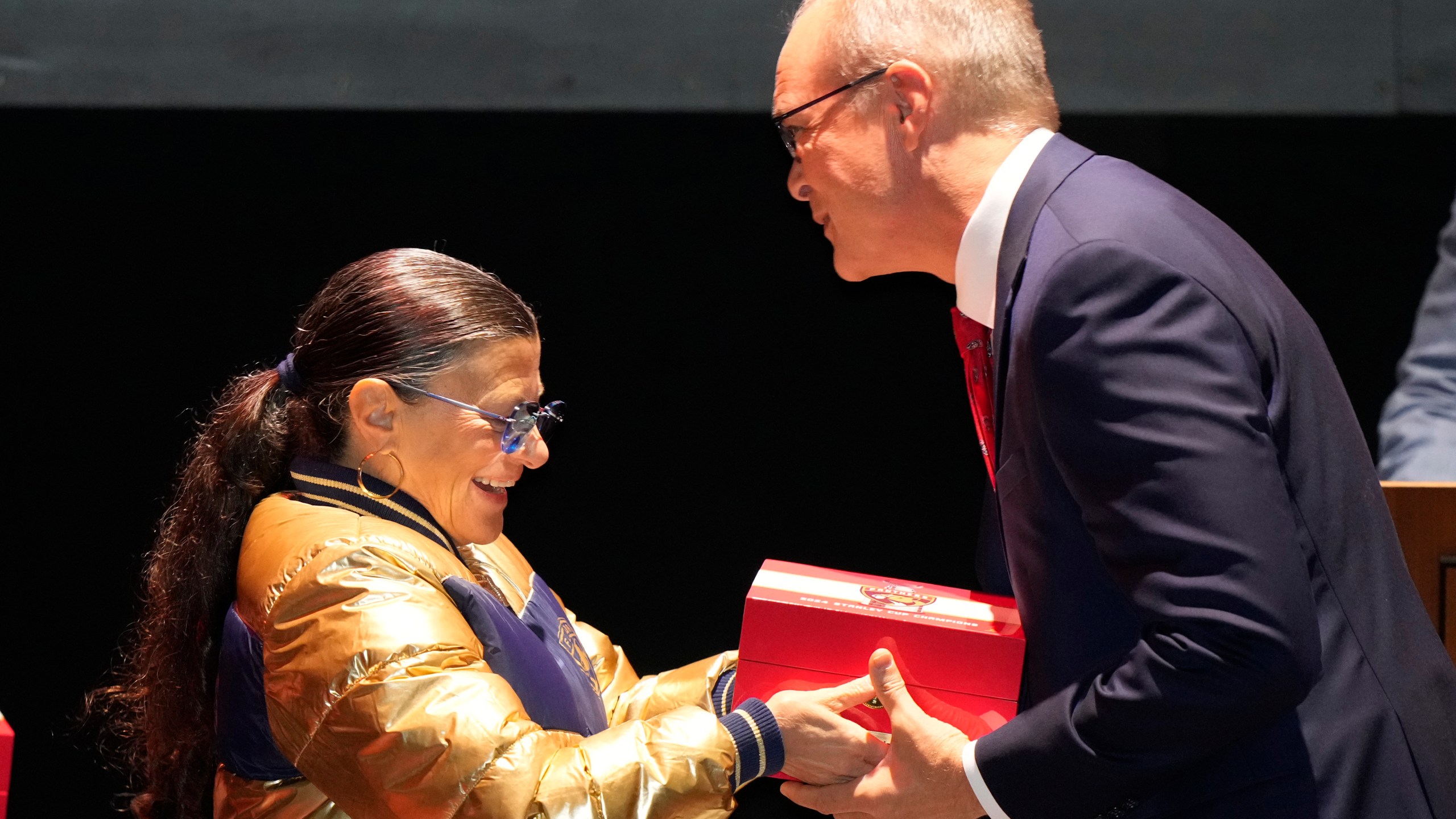 Florida Panthers head coach coach Paul Maurice, right, receives his Stanley Cup championship ring from Teresa Viola, wife of owner Vincent Viola, during a private ceremony commemorating the NHL team's Stanley Cup title last season, Monday, Oct. 7, 2024, in Fort Lauderdale, Fla. (AP Photo/Wilfredo Lee)