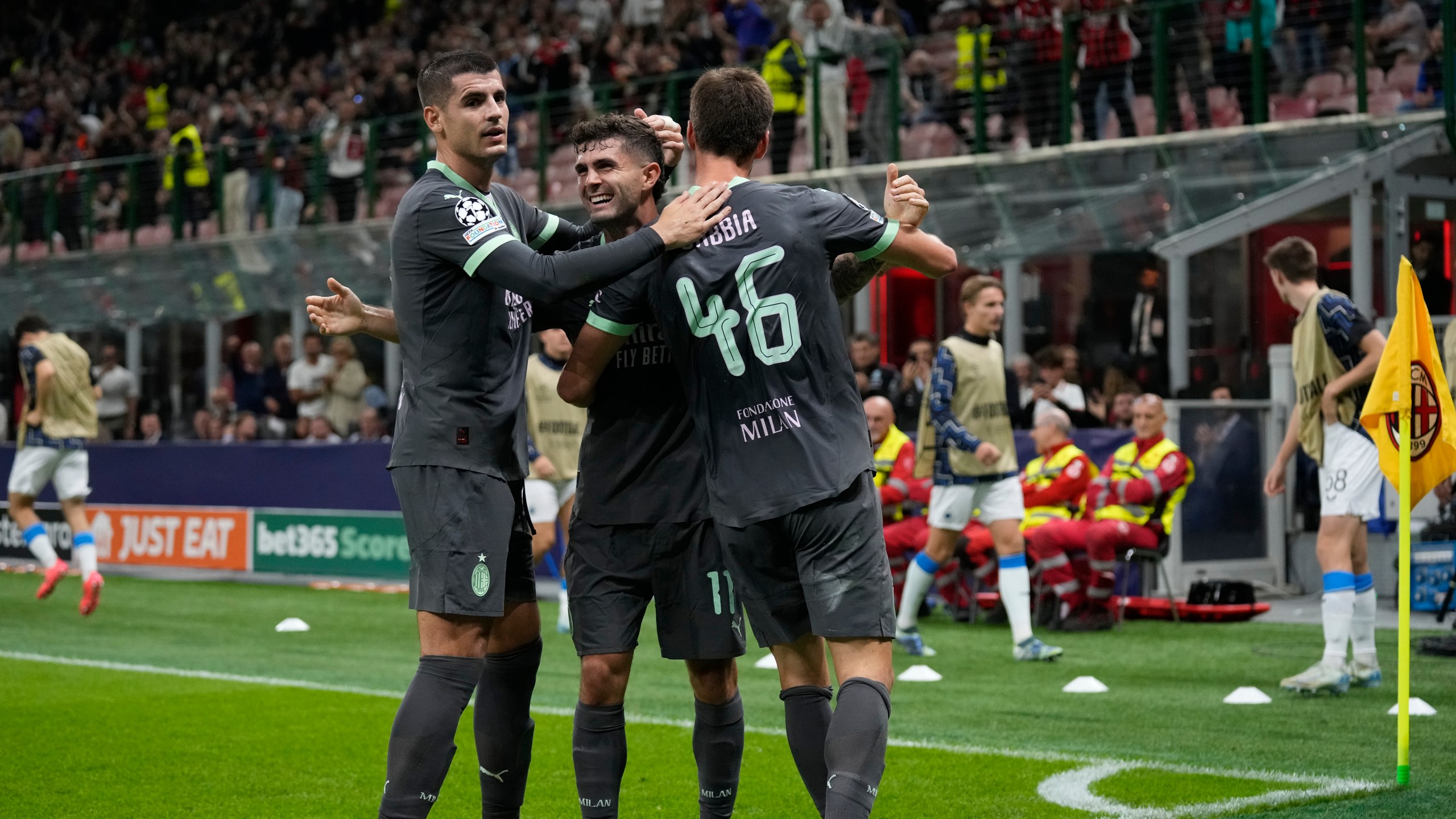 AC Milan's Christian Pulisic, center, celebrates with teammates after scoring his side's first goal during the Champions League opening phase soccer match between AC Milan and Club Brugge at the San Siro stadium in Milan, Italy, Tuesday, Oct. 22, 2024. (AP Photo/Antonio Calani)