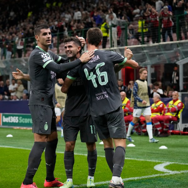 AC Milan's Christian Pulisic, center, celebrates with teammates after scoring his side's first goal during the Champions League opening phase soccer match between AC Milan and Club Brugge at the San Siro stadium in Milan, Italy, Tuesday, Oct. 22, 2024. (AP Photo/Antonio Calani)