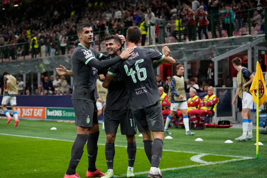 AC Milan's Christian Pulisic, center, celebrates with teammates after scoring his side's first goal during the Champions League opening phase soccer match between AC Milan and Club Brugge at the San Siro stadium in Milan, Italy, Tuesday, Oct. 22, 2024. (AP Photo/Antonio Calani)