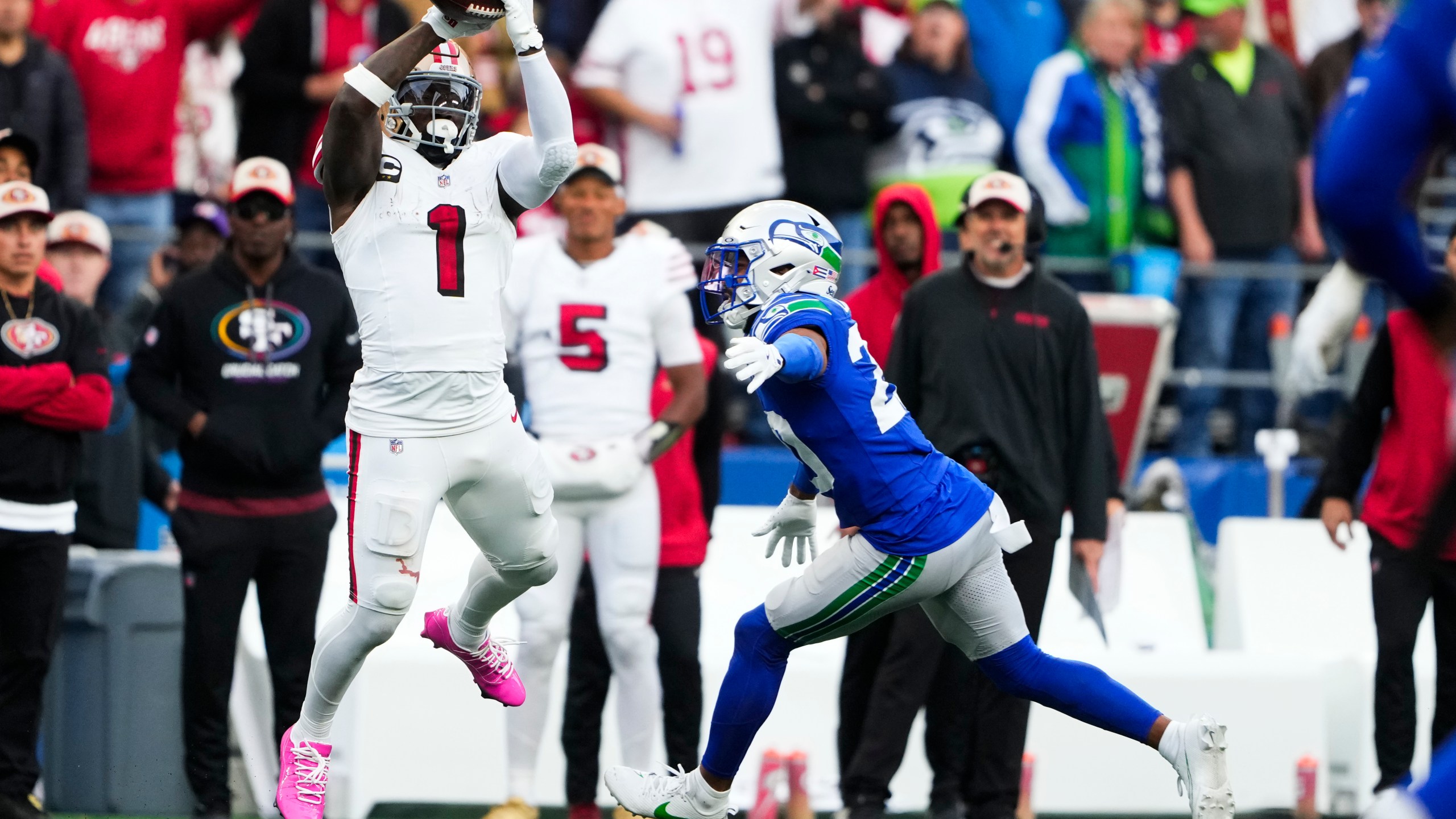 San Francisco 49ers wide receiver Deebo Samuel Sr. (1) makes a catch against Seattle Seahawks safety Julian Love, right, and would run it in for a touchdown during the first half of an NFL football game, Thursday, Oct. 10, 2024 in Seattle. (AP Photo/Lindsey Wasson)