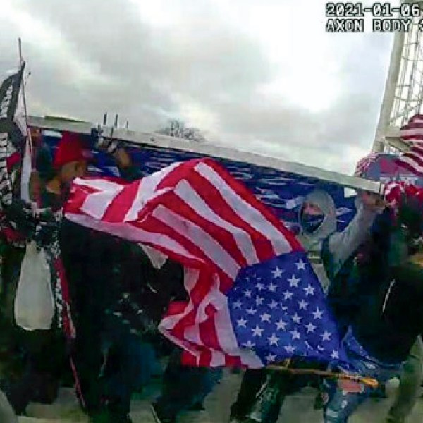 This image from a police-worn body camera and provided and annotated by the Justice Department shows Jeffrey Newcomb, 41, of Polk, Ohio, circled in red, on the East Front of the U.S. Capitol, Jan. 6, 2021, in Washington. Newcomb was arrested Oct. 22, 2024, on charges that he brought a massive "Trump" sign to the U.S. Capitol and joined other rioters in using it as a weapon against police officers during a mob attack. (Department of Justice via AP)