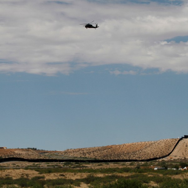 A surveillance helicopter traces a line in the sky above the Southwest border with Mexico at Sunland Park, N.M., Thursday, Aug. 22, 2024. (AP Photo/Morgan Lee, File)