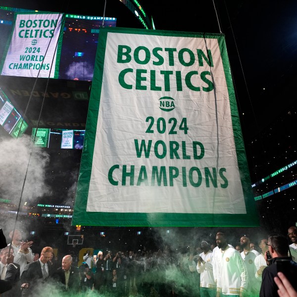 The Boston Celtics 2024 World Championship banner is raised prior to an NBA basketball game against the New York Knicks, Tuesday, Oct. 22, 2024, in Boston. (AP Photo/Charles Krupa)